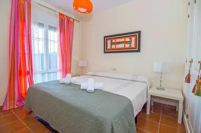 a bedroom with a bed and a window at Casa Albatros, Apartamentos Living Sur in Sanlúcar de Barrameda