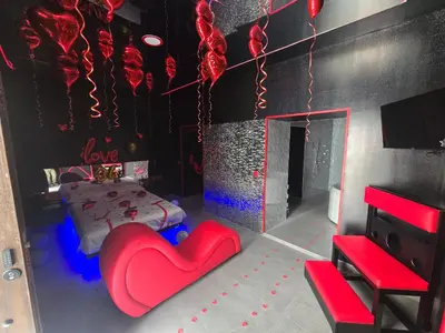 a room with a red heart chair and a bed at Parque erotico in Jerez de la Frontera