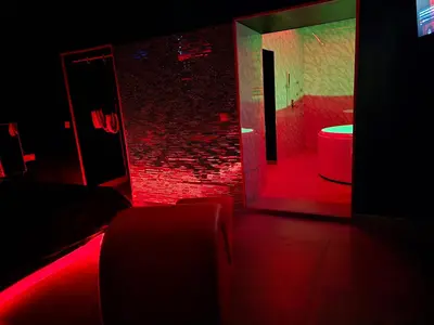 a dark room with a red lighted bathroom with a toilet at Parque erotico in Jerez de la Frontera