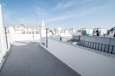a white wall with a fence on top of a building at Estudio Las Lavanderas de Cádiz in Cádiz