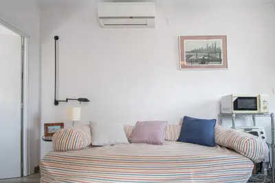 a couch sitting in a living room next to a tv at Estudio Las Lavanderas de Cádiz in Cádiz