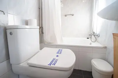 a white bathroom with a toilet and a bath tub at Estudio Las Lavanderas de Cádiz in Cádiz
