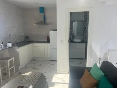 a living room with a couch and a kitchen at Dante Suite in Jerez de la Frontera