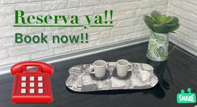 a table with two coffee cups on it next to a vase at Dante Suite in Jerez de la Frontera