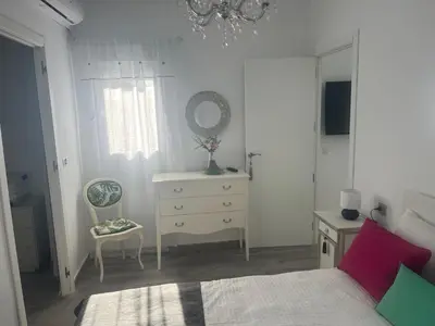 a bedroom with a bed and a dresser and a mirror at Dante Suite in Jerez de la Frontera