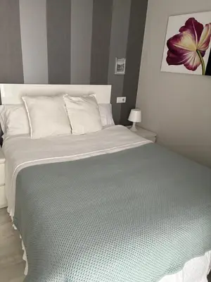 a bedroom with a large bed with a purple flower on the wall at Apartamento Castillo San Marcos in El Puerto de Santa María