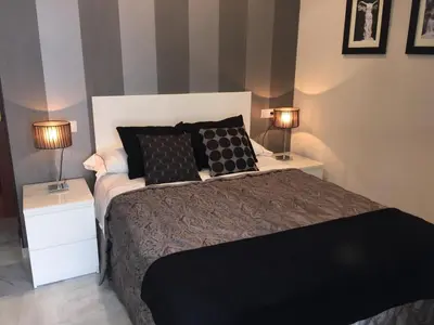 a bedroom with a bed with two night stands and two lamps at Apartamento Castillo San Marcos in El Puerto de Santa María