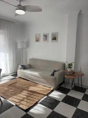 a living room with a couch and a checkered floor at Apartamento Clavel in Chipiona