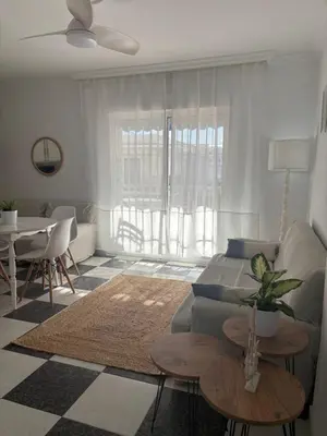 a living room with a couch and a table at Apartamento Clavel in Chipiona