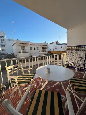 a white table and chairs on a balcony at Apartamento Clavel in Chipiona