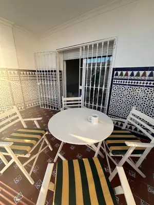 a room with a white table and chairs at Apartamento Clavel in Chipiona
