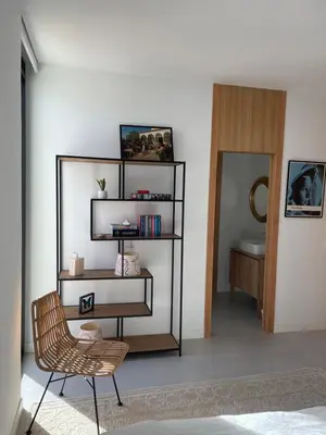 a room with a chair and a book shelf at Hostidy Villa Horacia Resort in Sanlúcar de Barrameda