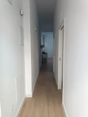 an empty hallway with white walls and wood floors at San Miguel in San Fernando