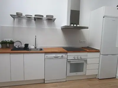 a kitchen with white cabinets and a white refrigerator at San Miguel in San Fernando