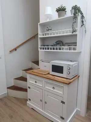 a microwave on a counter in a room with stairs at San Miguel in San Fernando