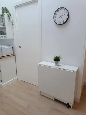 a white room with a clock and a table at San Miguel in San Fernando