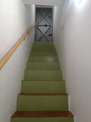 a stairway with a green staircase with a door at San Miguel in San Fernando