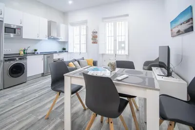 a kitchen and living room with a table and chairs at Estudio Viñamar Cádiz in Cádiz