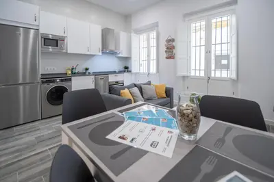a kitchen and living room with a table and chairs at Estudio Viñamar Cádiz in Cádiz
