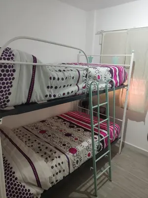a metal bunk bed with blankets and pillows on it at Apartamento Santa Teresa in Cádiz