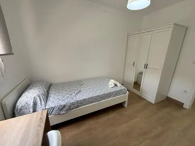 a small bedroom with a bed and a mirror at Cachucha Apartment in Puerto Real