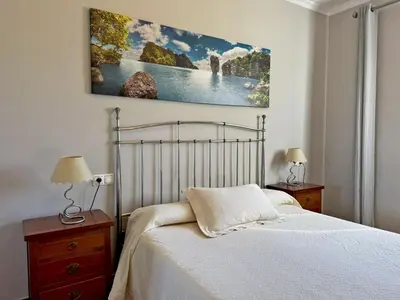 a bedroom with a bed and a painting on the wall at El Bosque del Duende - Ole Solutions in Arcos de la Frontera