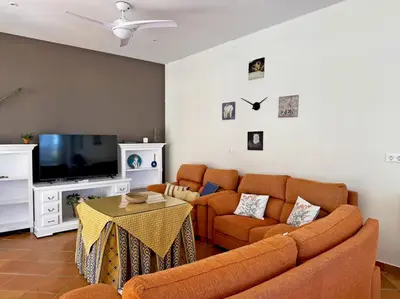 a living room with a couch and a tv at El Bosque del Duende - Ole Solutions in Arcos de la Frontera