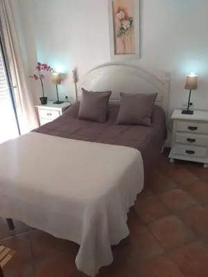 a bedroom with a large bed and two night stands at centro Puerto de Santamaria in El Puerto de Santa María