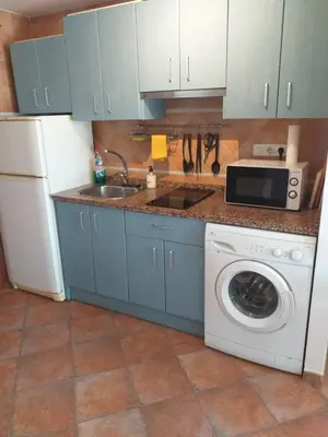 a kitchen with blue cabinets and a sink and a washing machine at centro Puerto de Santamaria in El Puerto de Santa María