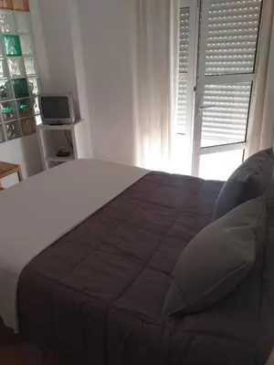 a bedroom with a large bed with a window at centro Puerto de Santamaria in El Puerto de Santa María