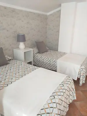 a room with two beds and a table with a lamp at centro Puerto de Santamaria in El Puerto de Santa María