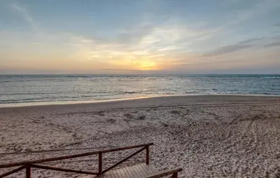 a bench sitting on a beach with the ocean at Awesome Home In Rota With Wifi in Rota