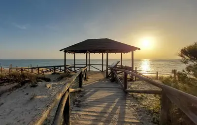 a wooden boardwalk to the beach with a hut at Awesome Home In Rota With Wifi in Rota