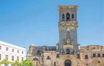 a building with a tower with a clock on it at Casa Chico in Arcos de la Frontera