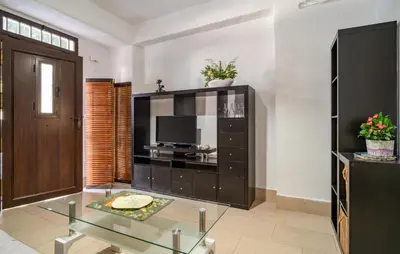 a living room with a glass table and a tv at Casa Chico in Arcos de la Frontera