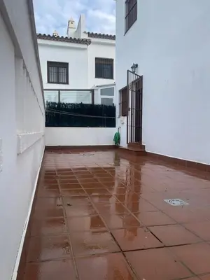 an empty courtyard of a white house with water on the floor at JC 7 Chalet in Chiclana de la Frontera
