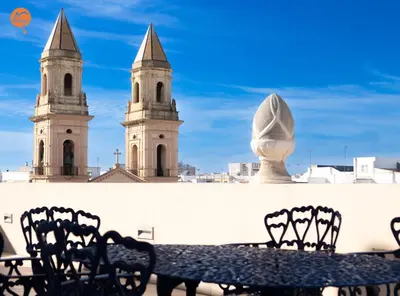 a table and chairs in front of two towers at Penthouse Plaza San Antonio Grupo AC Gestion in Cádiz