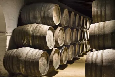 a row of wooden barrels in a cellar at Apartamento Al Sur del Sur in Sanlúcar de Barrameda