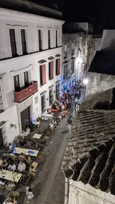 a group of people sitting at tables outside a building at Casa Del Encanto Arcos in Arcos de la Frontera