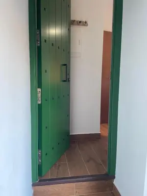 a green door in a room with a tile floor at Casa Del Encanto Arcos in Arcos de la Frontera
