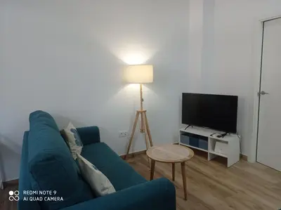 a living room with a blue couch and a tv at Apartamento Mar III in San Fernando