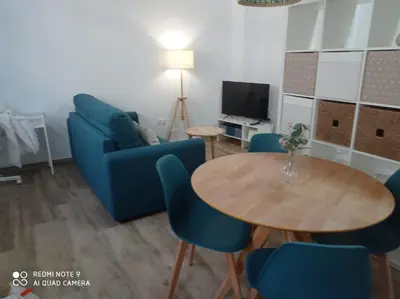 a living room with a blue couch and a table at Apartamento Mar III in San Fernando