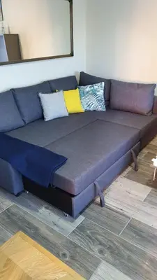 a blue couch with pillows on it in a room at Estudio playa la muralla in El Puerto de Santa María