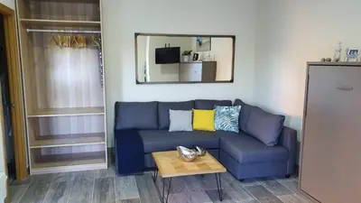 a blue couch in a living room with a table at Estudio playa la muralla in El Puerto de Santa María