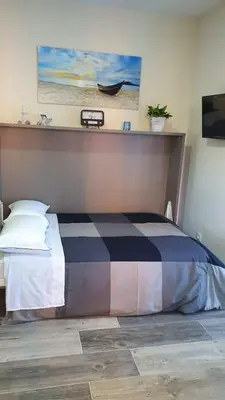 a bedroom with a bed with a painting on the wall at Estudio playa la muralla in El Puerto de Santa María