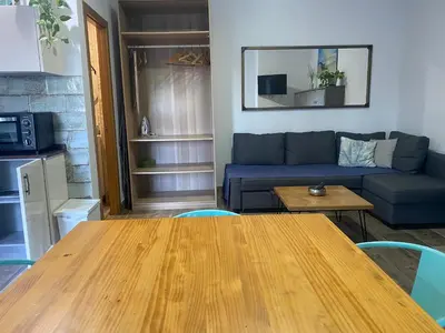 a living room with a blue couch and a table at Estudio playa la muralla in El Puerto de Santa María