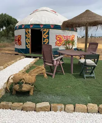 a tent with a table and chairs in front of it at La via de la Yurta in Cádiz