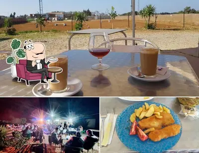 a table with a glass of wine and a plate of food at La via de la Yurta in Cádiz