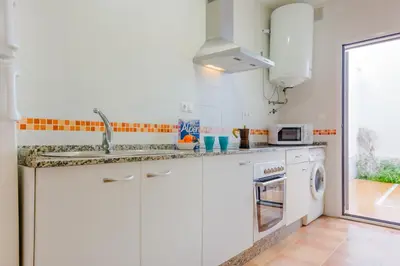 a white kitchen with a sink and a dishwasher at Apartamentos Ribera del Puerto in El Puerto de Santa María