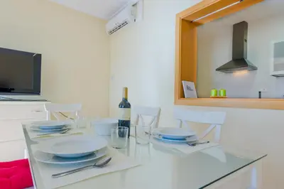 a kitchen with a glass table with a bottle of wine at Apartamentos Ribera del Puerto in El Puerto de Santa María